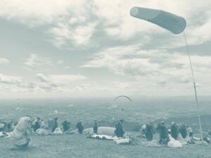Piloten und Windsack am Startplatz Rubbio über der Poebene